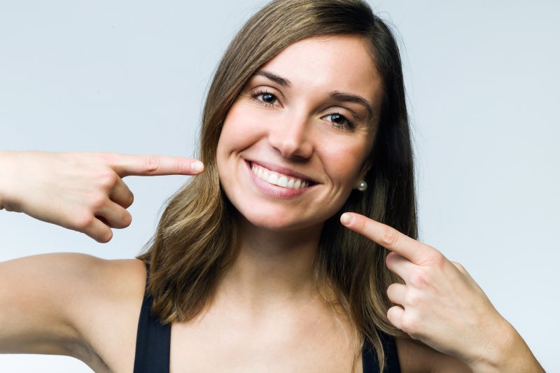 Woman pointing to her smile